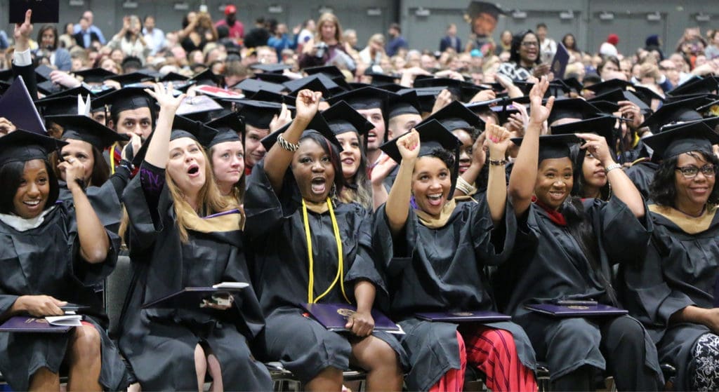 Students cheering during graduation ceremony