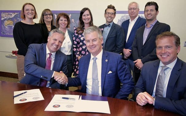 Avila President Jim Burkee (center), Bruce Ranney, president (left), and Joseph Mroz (right), executive vice president of K-12 Teachers Alliance sign the partnership agreement, joined by Avila University leadership team